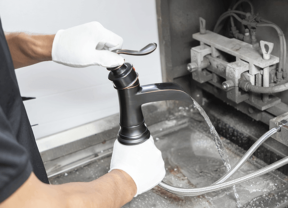 a worker is having water testing of a bathroom faucet